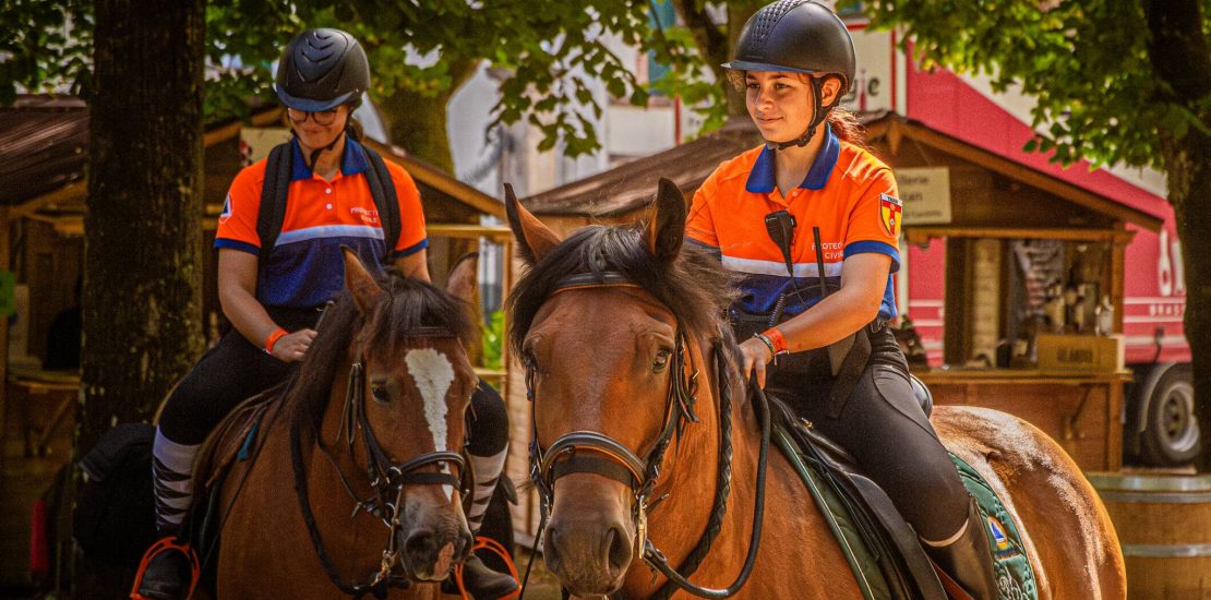 Deux bénévoles de la Protection Civile du Tarn sur le dos des cheveaux de la brigade équestre